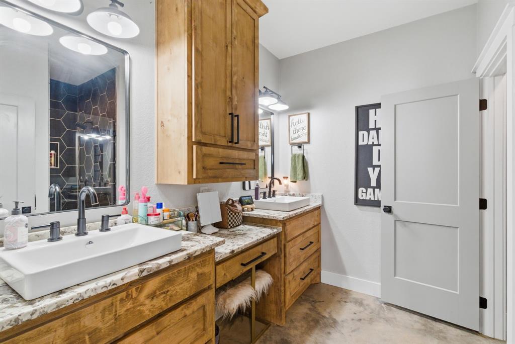 1734 Davis Road Lipan, TX 76462 - Photo 13 of 40 a bathroom with double vanity sinks a mirror and a shower