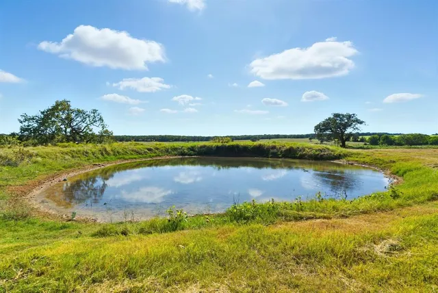 a view of a lake in front of house with yard and outdoor seating