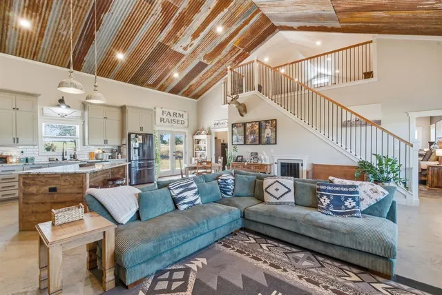 a living room with furniture and a view of kitchen