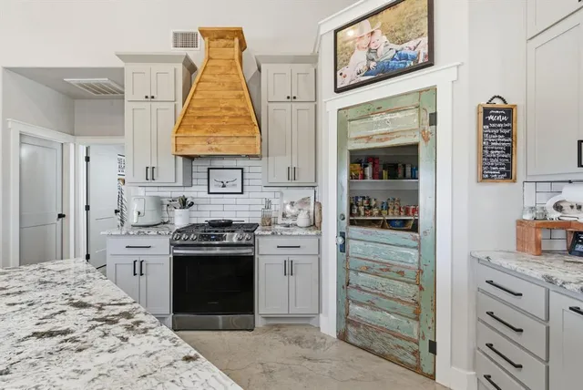 a kitchen with a stove and white cabinets