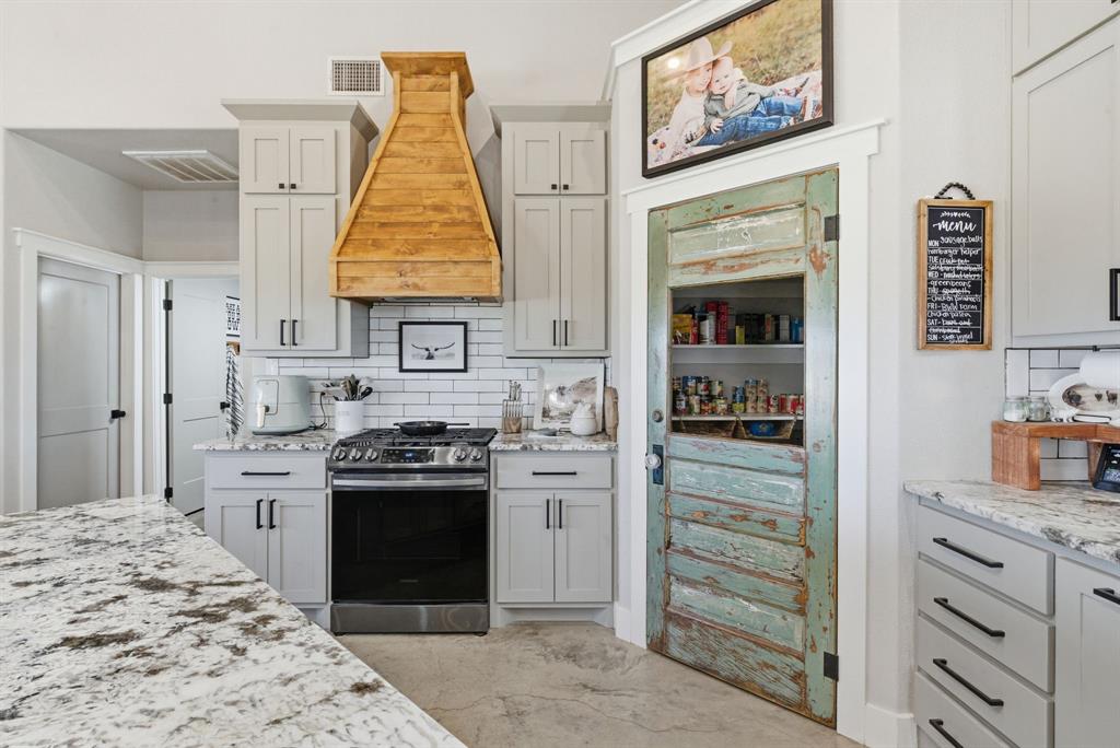 1734 Davis Road Lipan, TX 76462 - Photo 9 of 40 a kitchen with a stove and white cabinets