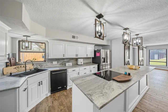 a kitchen with a sink a stove and cabinets
