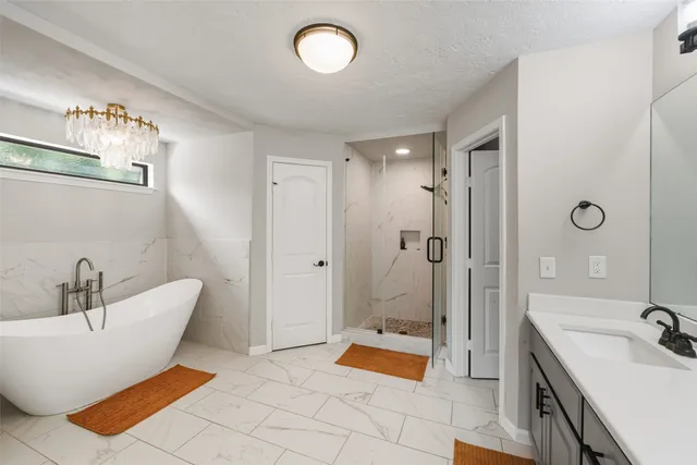 a spacious bathroom with a tub sink and shower