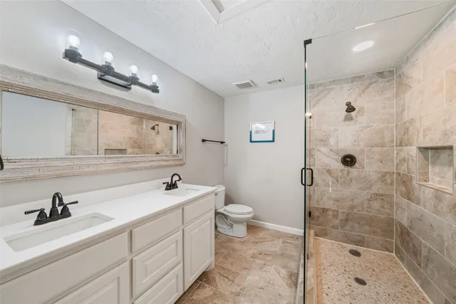 a bathroom with a sink a toilet and shower