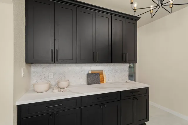 a kitchen with stainless steel appliances a stove and white cabinets