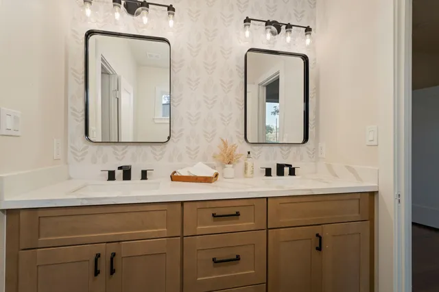 a bathroom with double vanity sinks and a mirror