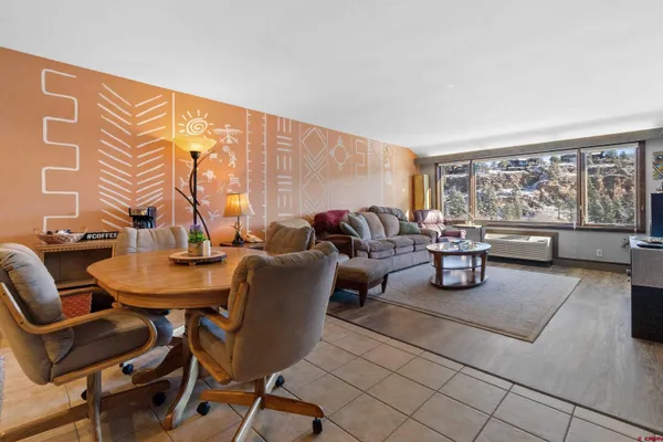 a living room with furniture and a floor to ceiling window