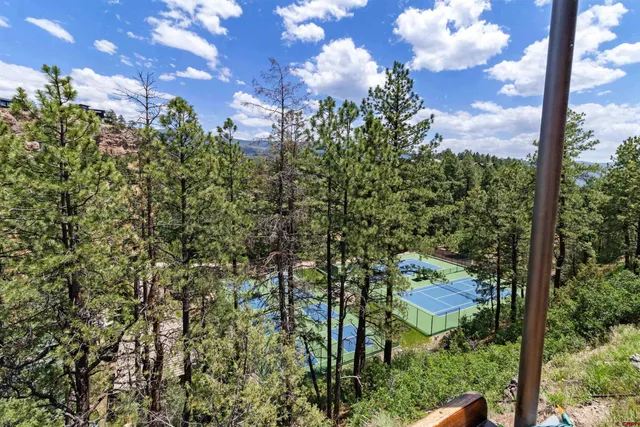 a view of a balcony with chairs and iron fence