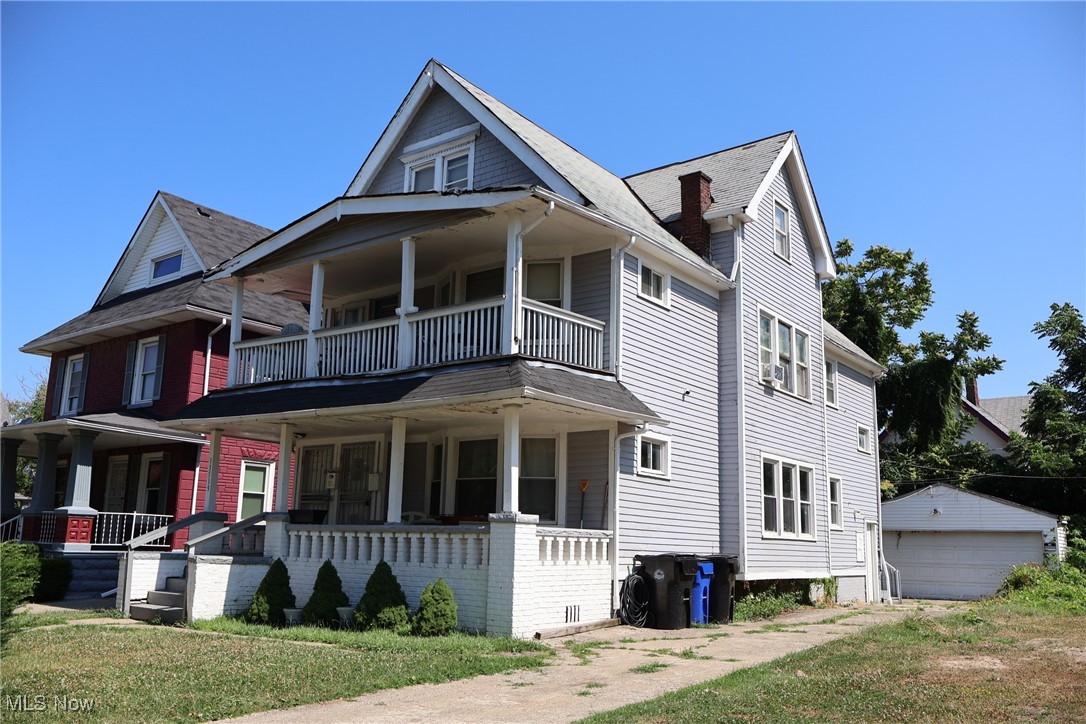 13519 Ashburton Road Cleveland, OH 44110 - Photo 2 of 12 View of front of property with a balcony, covered porch, a garage, and an outdoor structure