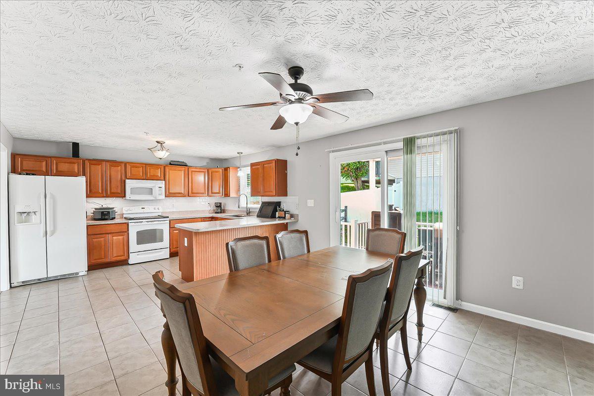 107 Britton Drive Rising Sun, MD 21911 - Photo 14 of 30 a dining room with stainless steel appliances kitchen island granite countertop a dining table chairs and a refrigerator
