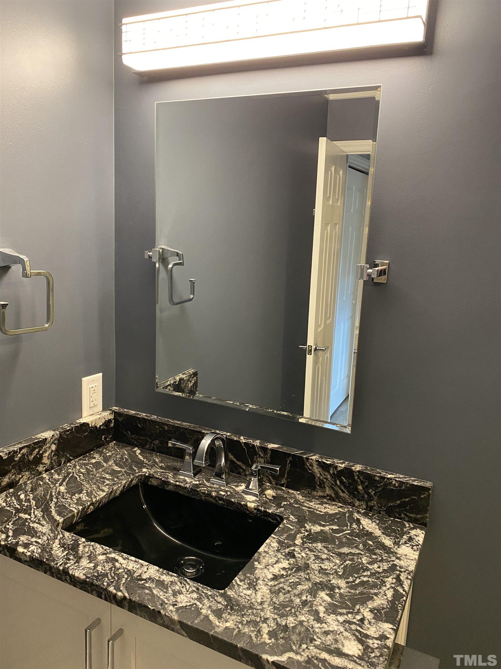4422 Wellington Ridge Loop, Unit 4422 Cary, NC 27518 - Photo 20 of 40 a bathroom with a granite countertop sink and a stove
