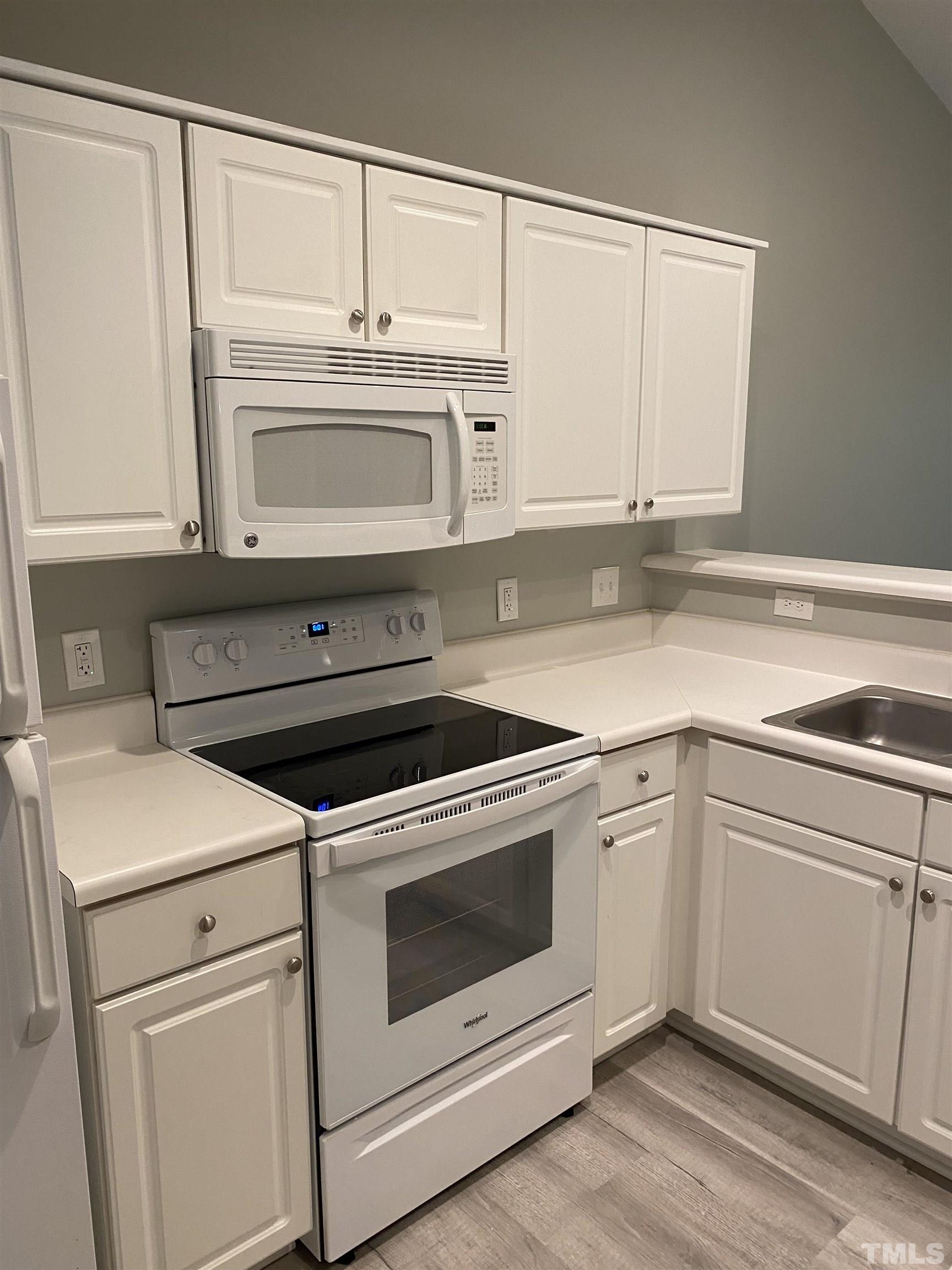 4422 Wellington Ridge Loop, Unit 4422 Cary, NC 27518 - Photo 22 of 40 a kitchen with granite countertop white cabinets and white appliances