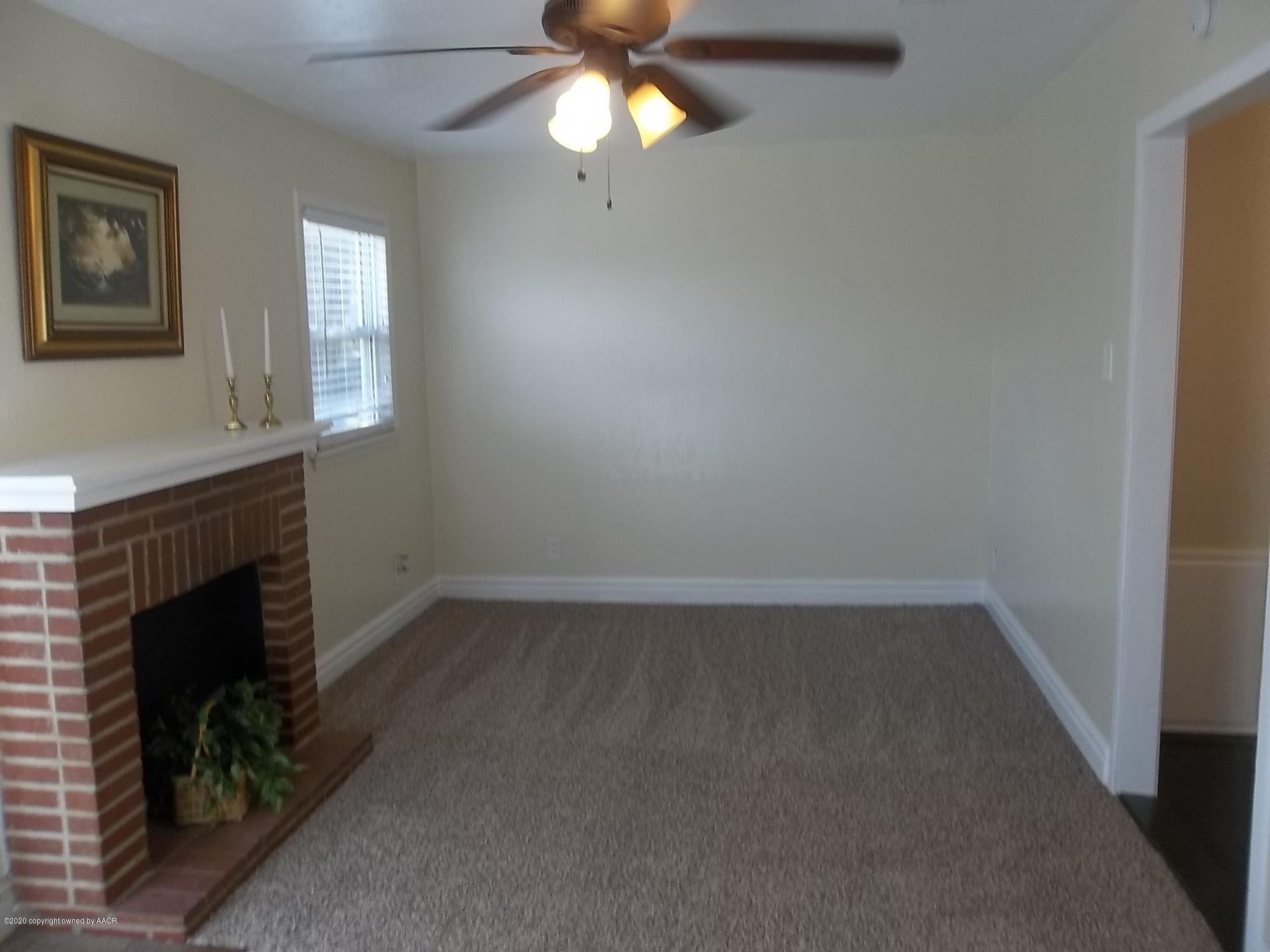 4117 South Tyler Street Amarillo, TX 79110 - Photo 12 of 18 an empty room with a fireplace and fan