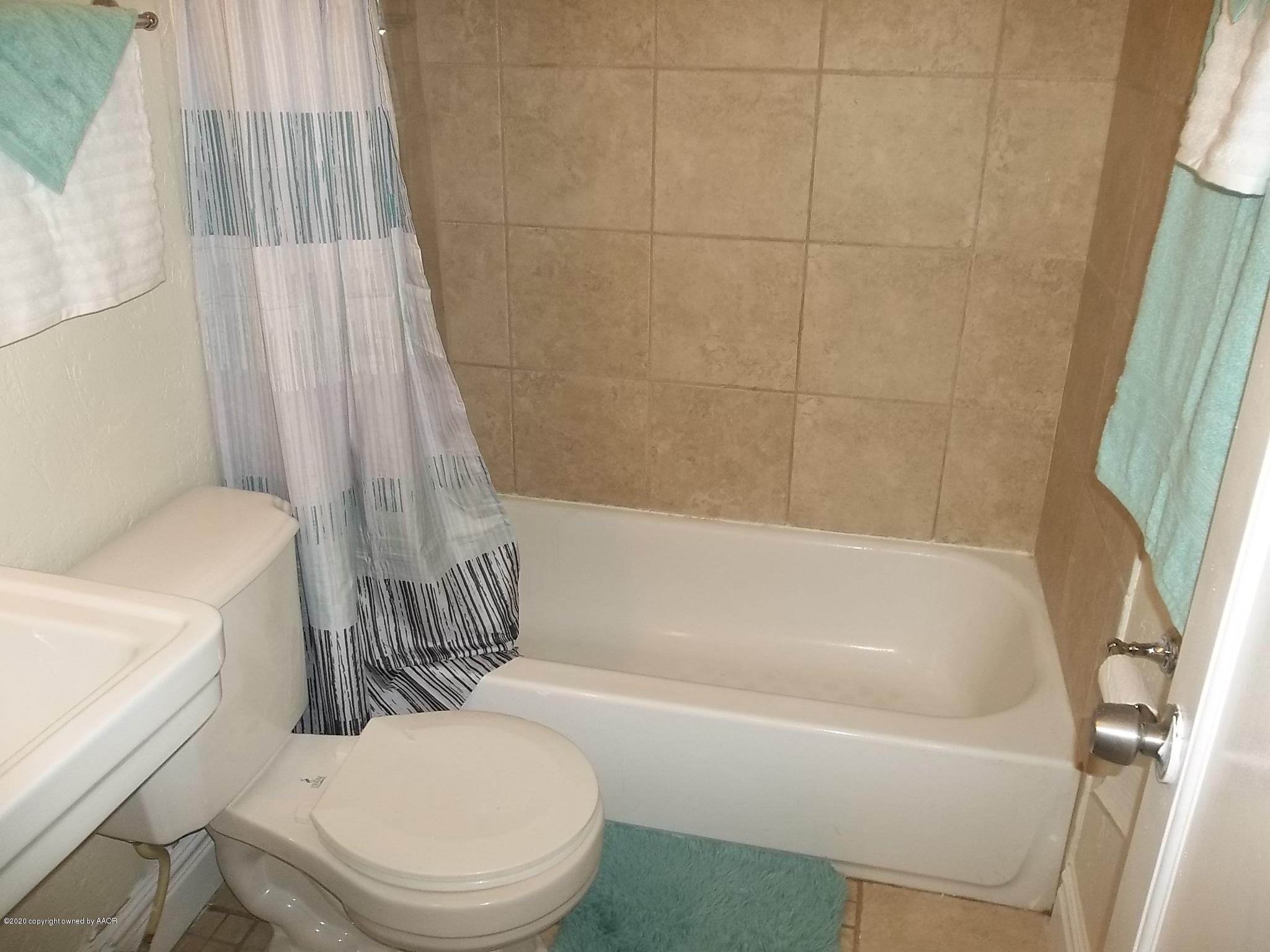 4117 South Tyler Street Amarillo, TX 79110 - Photo 14 of 18 a white bath tub sitting next to a white toilet
