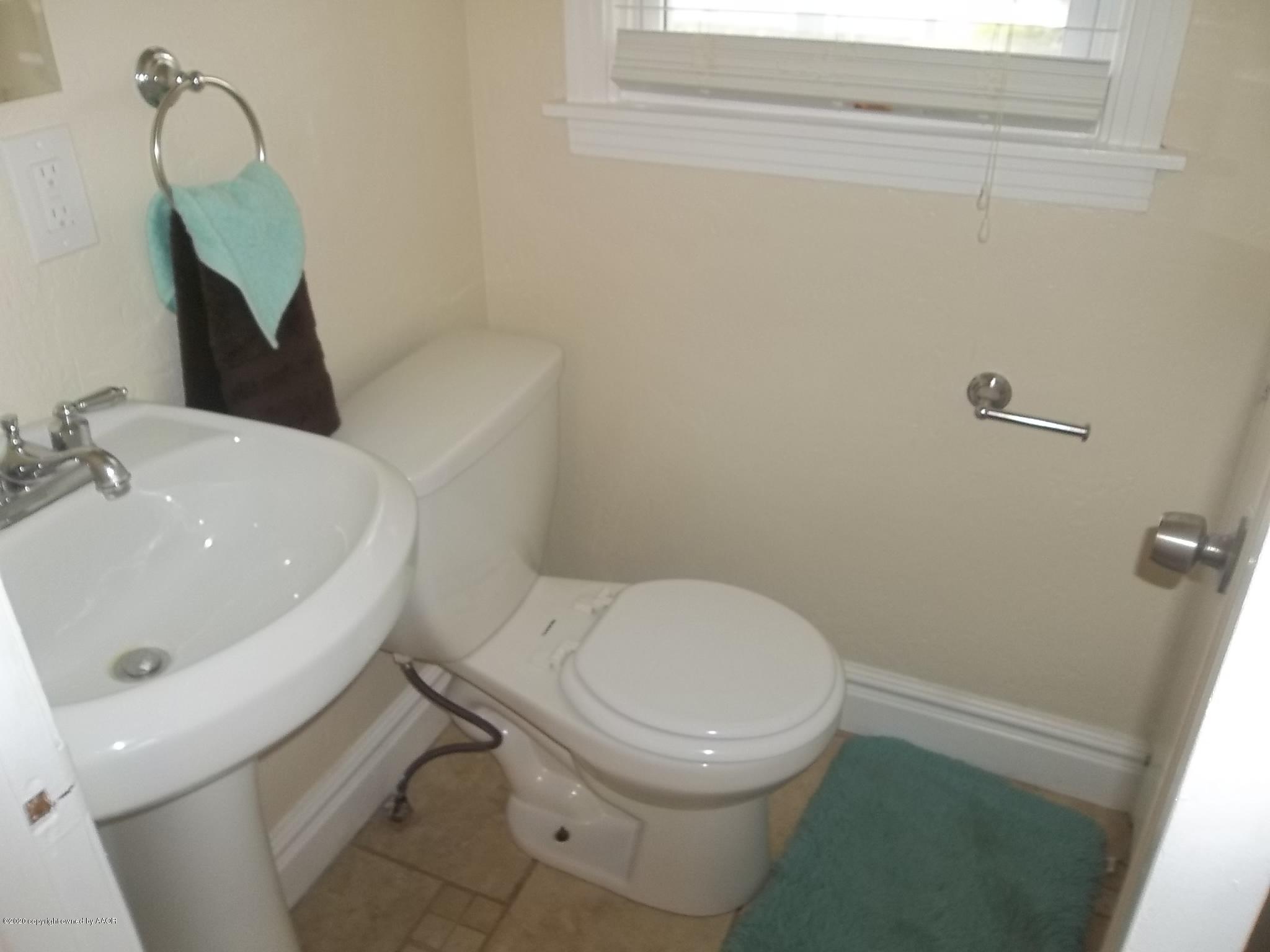 4117 South Tyler Street Amarillo, TX 79110 - Photo 15 of 18 a white toilet sitting next to a bathroom sink