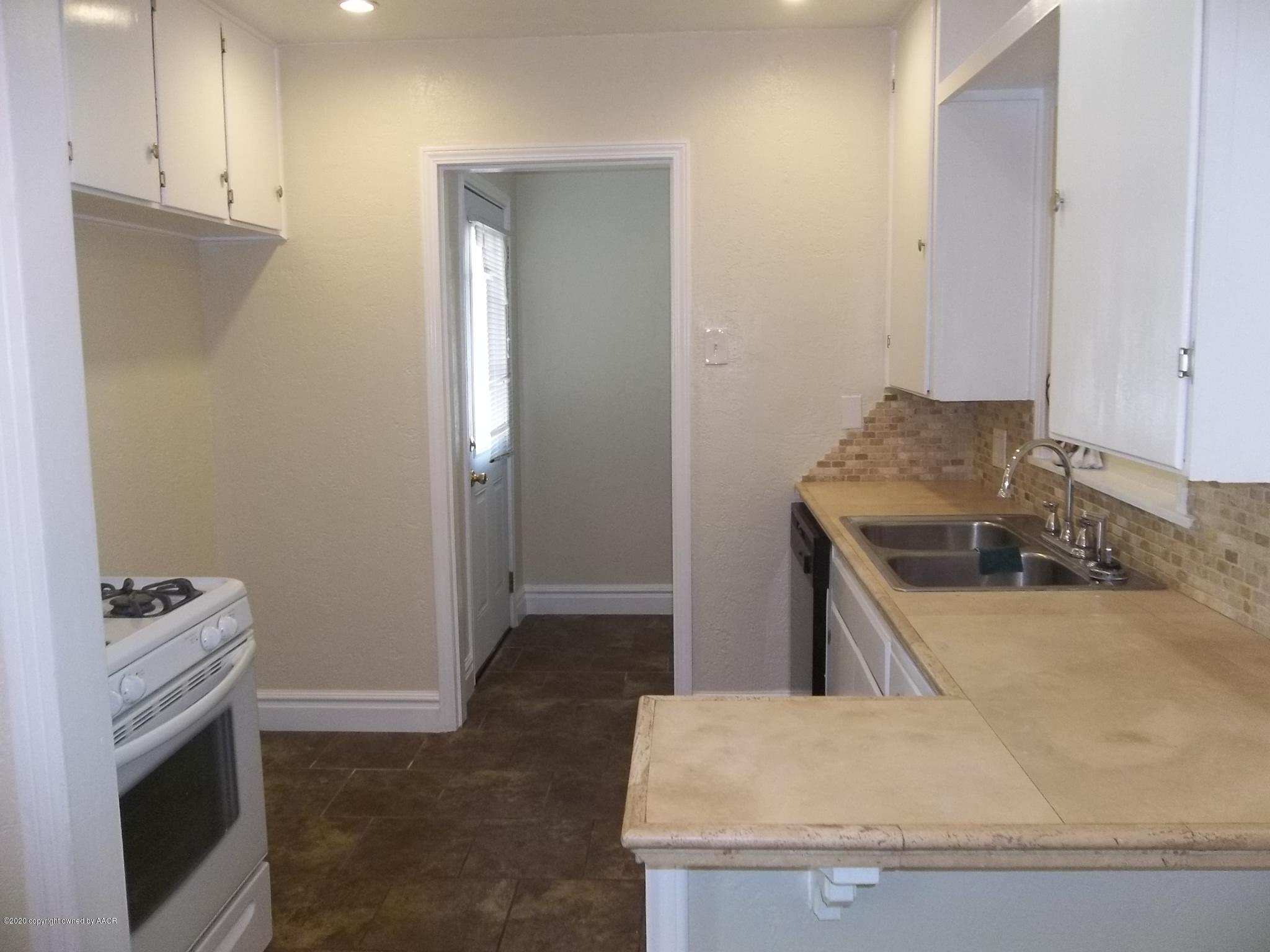 4117 South Tyler Street Amarillo, TX 79110 - Photo 8 of 18 a kitchen with granite countertop a sink stove and refrigerator