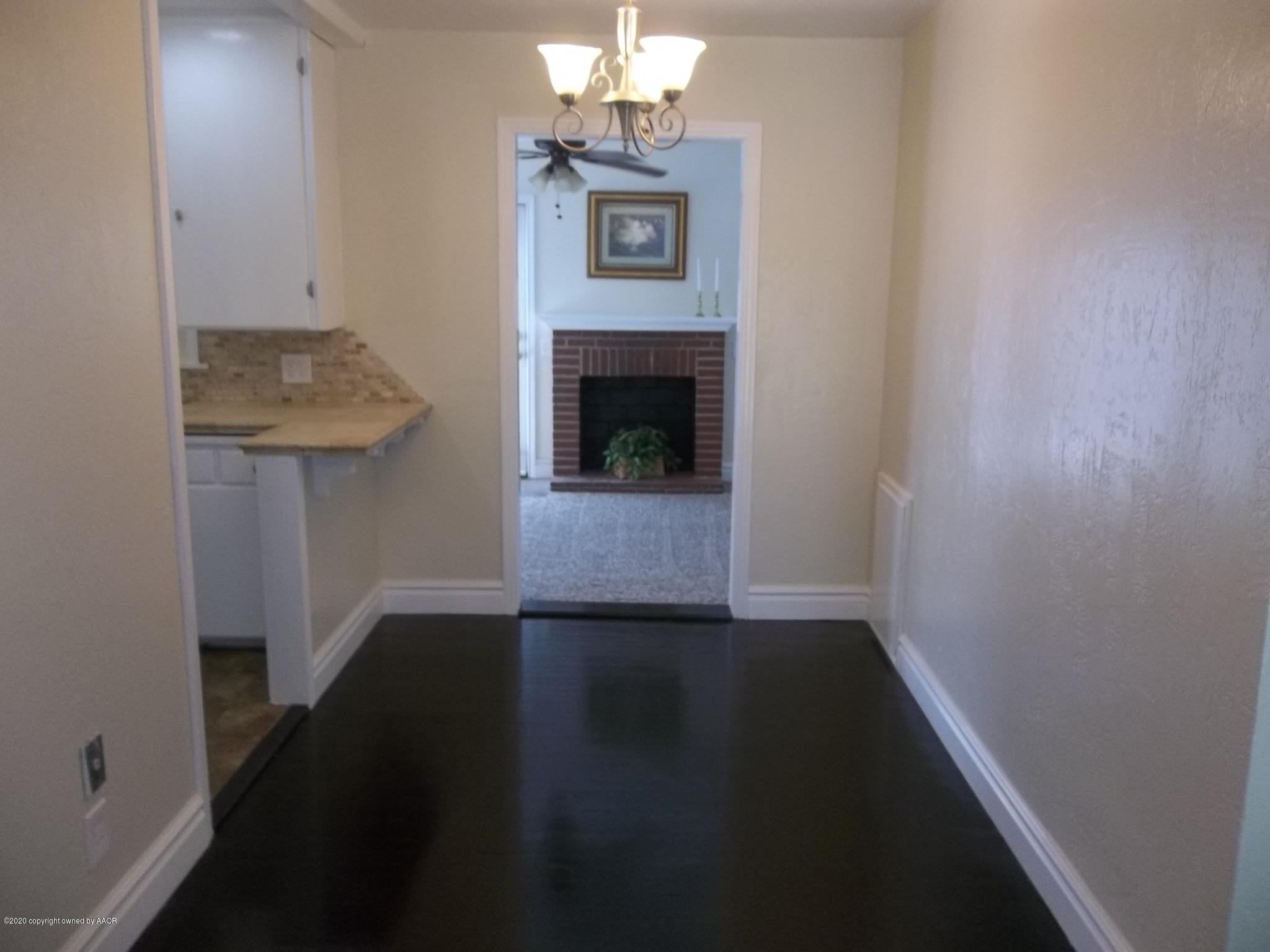 4117 South Tyler Street Amarillo, TX 79110 - Photo 9 of 18 a view of a hallway with wooden floor and a fireplace