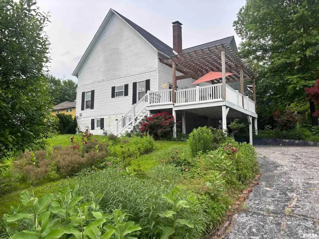 a front view of a house with a yard and trees