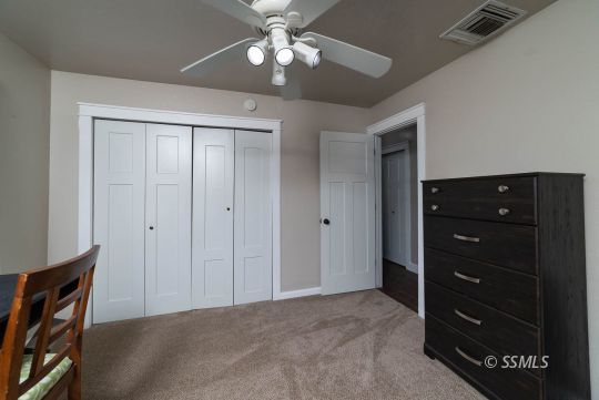 313 East Haloid Avenue Ridgecrest, CA 93555 - Photo 16 of 39 a bedroom with a dresser and a chandelier