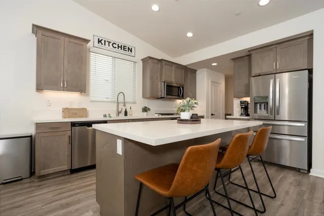 a kitchen with stainless steel appliances granite countertop a sink a stove a refrigerator and cabinets