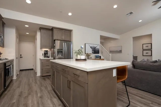 a kitchen with a dining table chairs and refrigerator