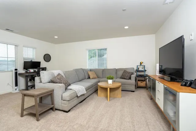 a living room with furniture a flat screen tv and a window