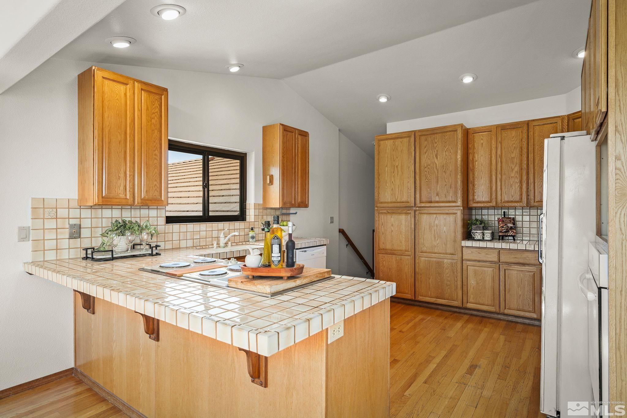 80 Cassas Court Reno, NV 89511 - Photo 13 of 40 a kitchen with kitchen island granite countertop a sink and a refrigerator