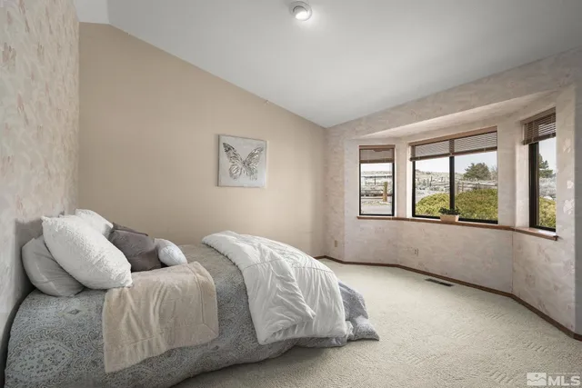 an empty room with chandelier fan and windows