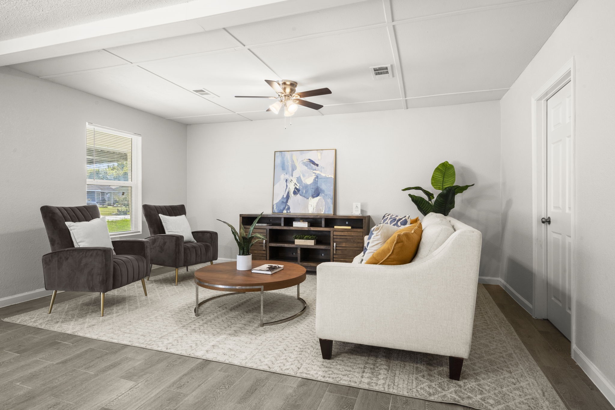 a living room with furniture a chandelier and a potted plant