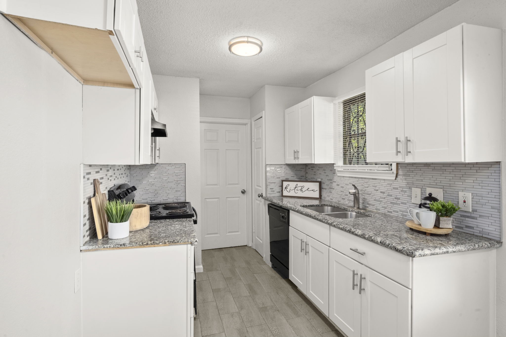 5219 Myrtlewood Street Houston, TX 77033 - Photo 15 of 36 a kitchen with a sink a stove cabinets and counter space