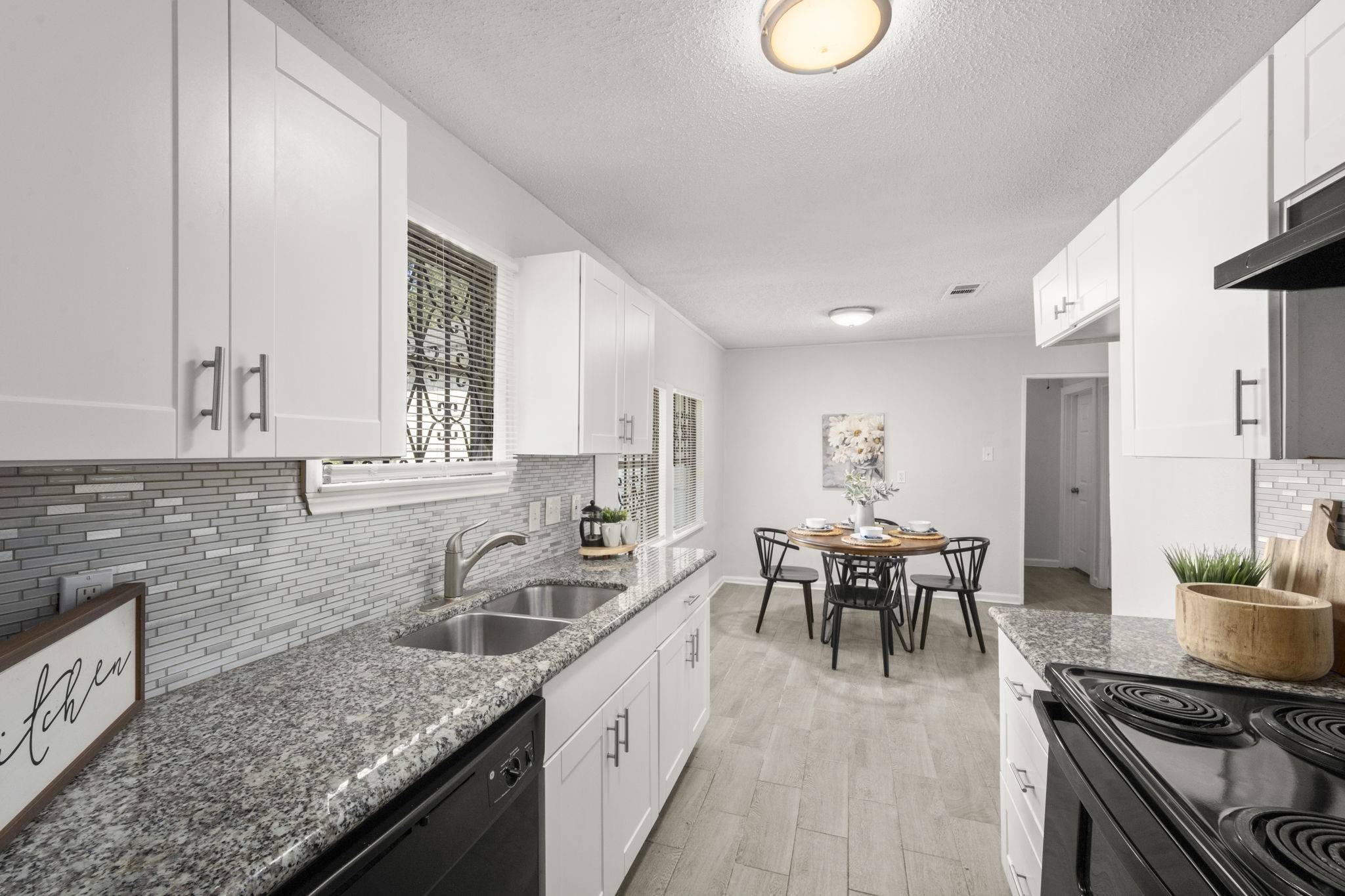 5219 Myrtlewood Street Houston, TX 77033 - Photo 18 of 36 a kitchen with granite countertop a sink stove and cabinets