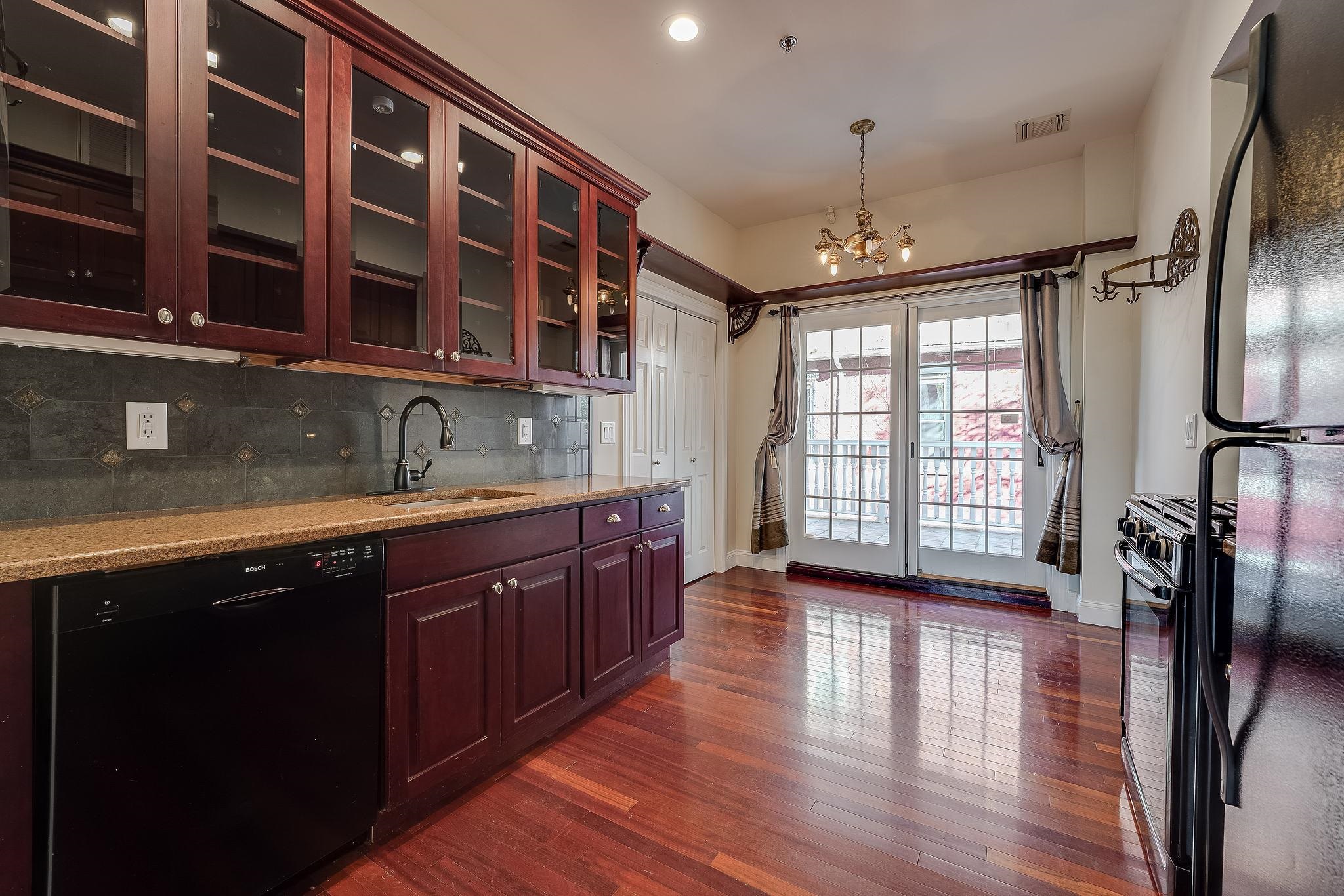 a kitchen with stainless steel appliances granite countertop a stove a sink and wooden floors
