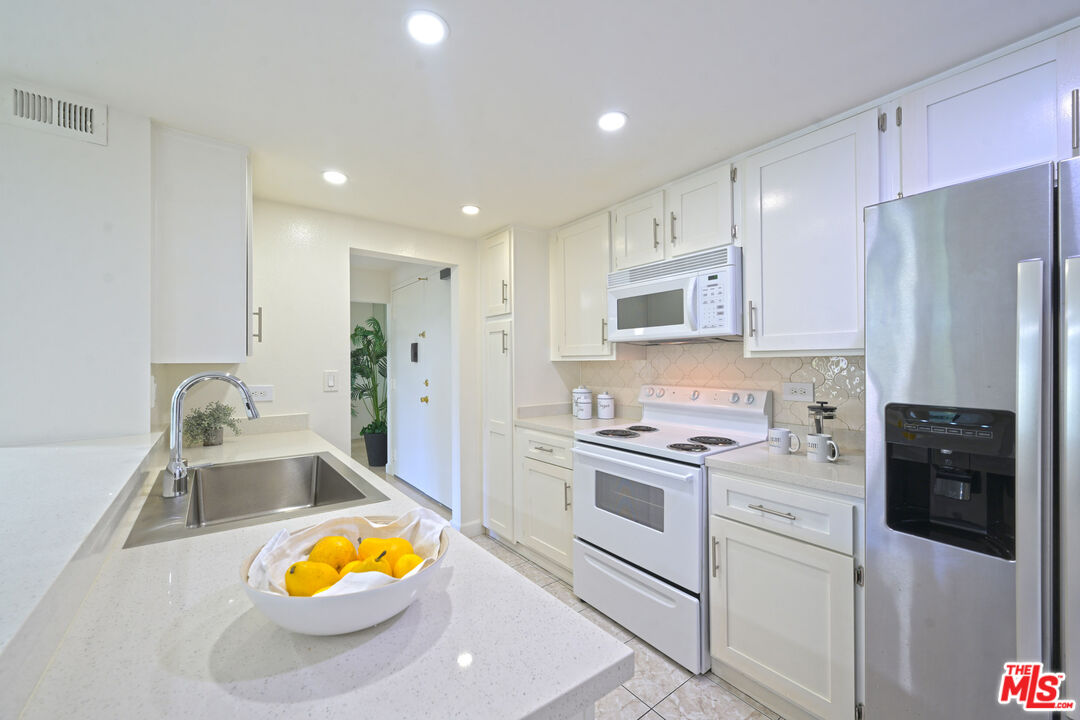 10535 Wilshire Boulevard, Unit 414 Los Angeles, CA 90024 - Photo 11 of 41 a kitchen with stainless steel appliances granite countertop a stove a refrigerator and a sink