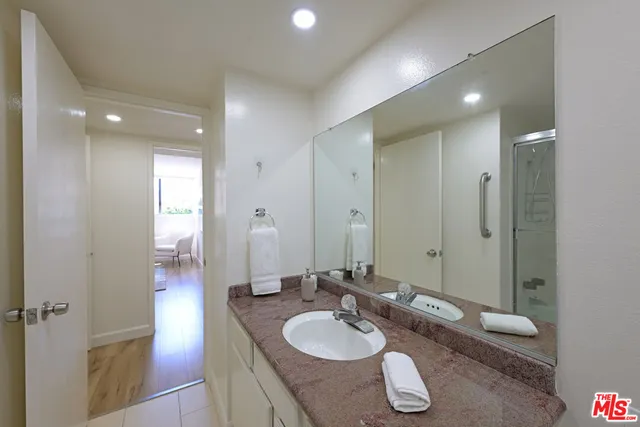 a bathroom with a granite countertop sink and a mirror
