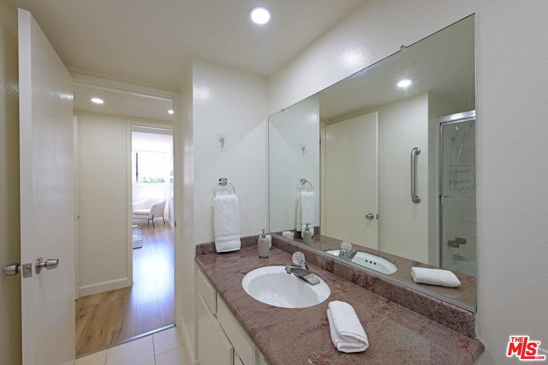 10535 Wilshire Boulevard, Unit 414 Los Angeles, CA 90024 - Photo 26 of 41 a bathroom with a granite countertop sink and a mirror
