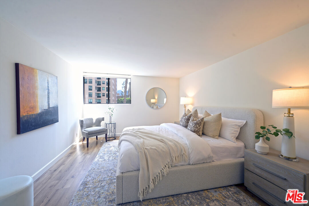 10535 Wilshire Boulevard, Unit 414 Los Angeles, CA 90024 - Photo 27 of 41 a bedroom with a bed lamps and wooden floor