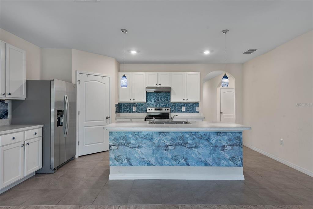 247 Old Mill Edgewater, FL 32141 - Photo 13 of 67 a large kitchen with granite countertop a refrigerator a stove a sink a washer and dryer