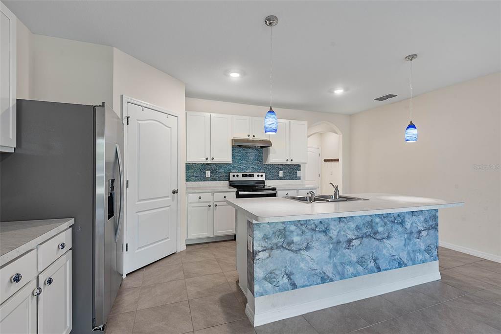 247 Old Mill Edgewater, FL 32141 - Photo 14 of 67 a kitchen with kitchen island granite countertop a stove cabinets and refrigerator