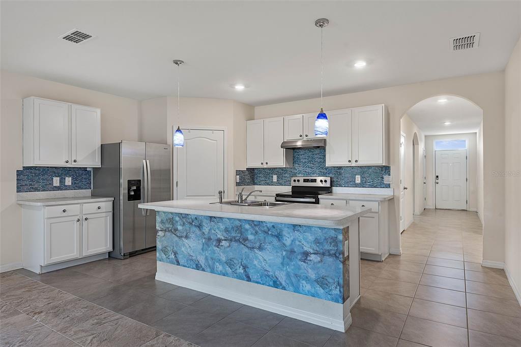 247 Old Mill Edgewater, FL 32141 - Photo 15 of 67 a large kitchen with kitchen island a sink stainless steel appliances and cabinets