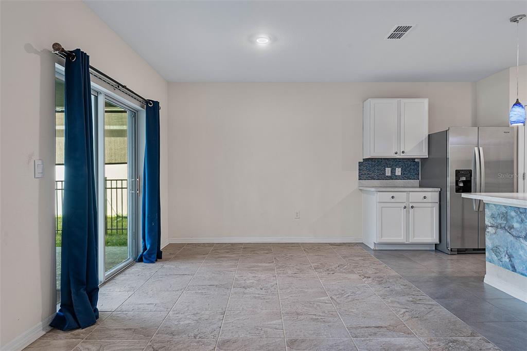 247 Old Mill Edgewater, FL 32141 - Photo 10 of 67 a kitchen with white cabinets and refrigerator
