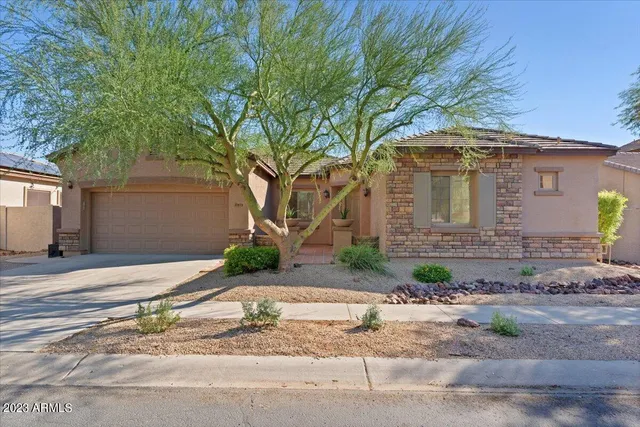 a front view of a house with a yard and potted plants