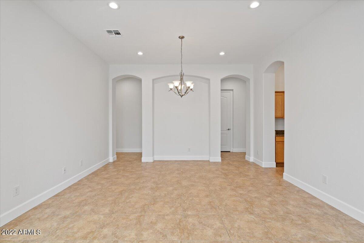 2413 West Sienna Bouquet Place Phoenix, AZ 85085 - Photo 12 of 61 an empty room with chandelier fan and windows