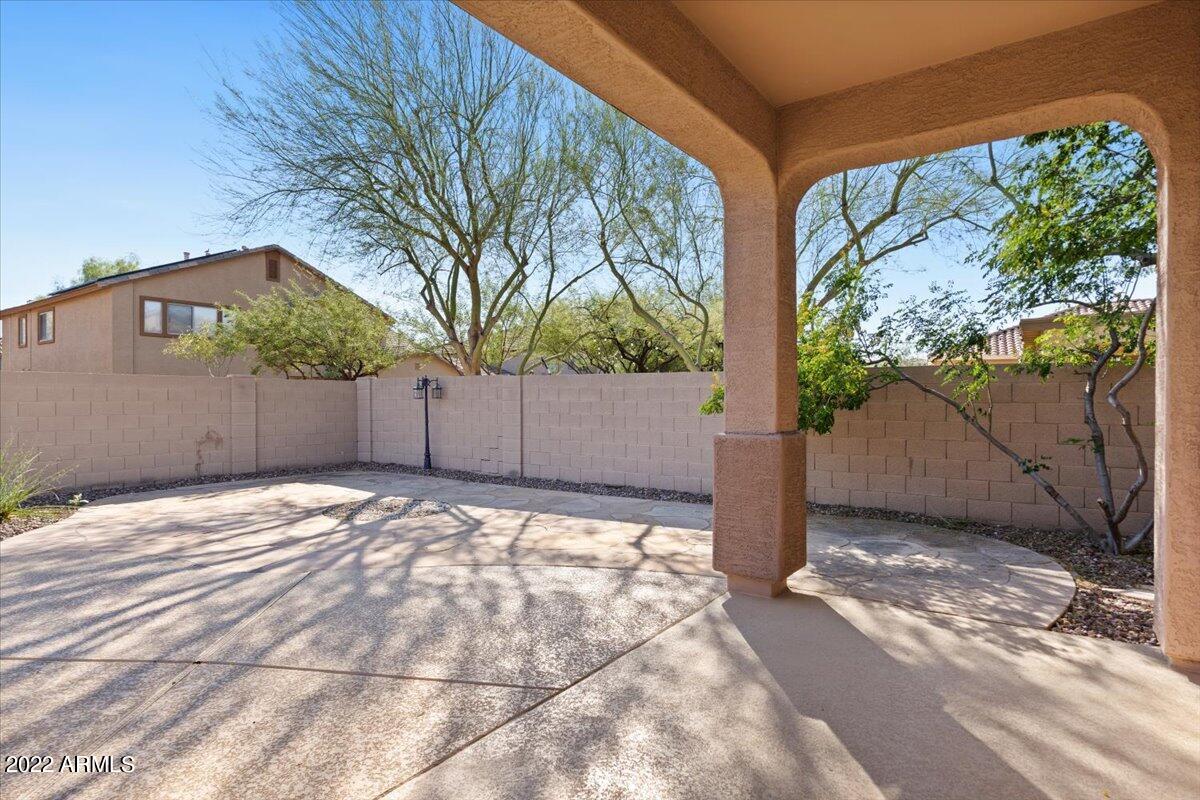 2413 West Sienna Bouquet Place Phoenix, AZ 85085 - Photo 6 of 61 a view of backyard with large trees and wooden fence