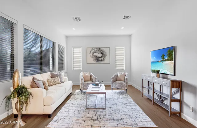 an empty room with chandelier fan and windows