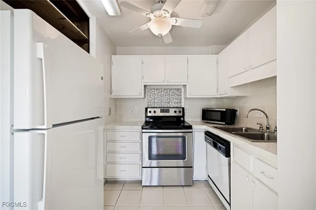 a kitchen with white cabinets and appliances