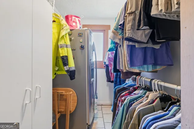 a view of walk in closet with clothes and shoes