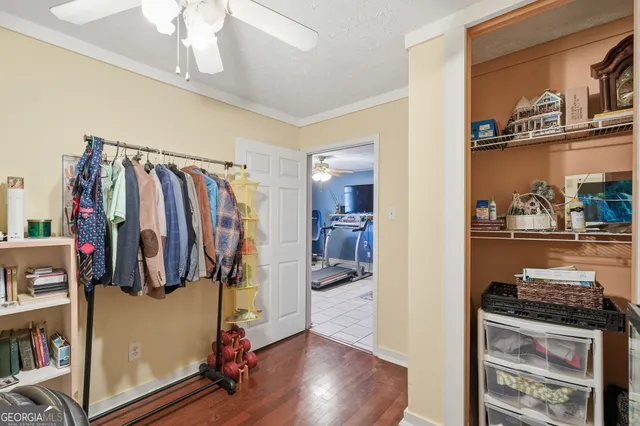 a view of walk in closet with clothes and shoes