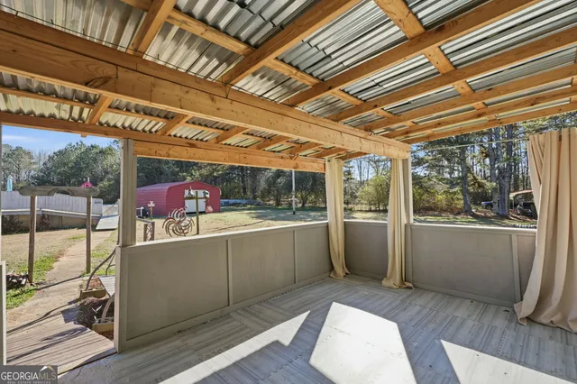 a view of a porch with furniture and wooden floor