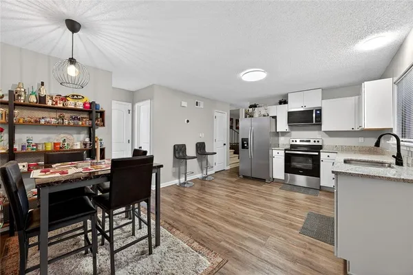 a kitchen with a table chairs microwave and cabinets