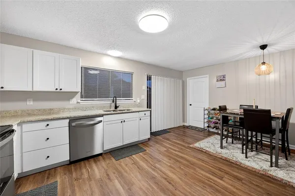a kitchen with granite countertop a sink cabinets and wooden floor